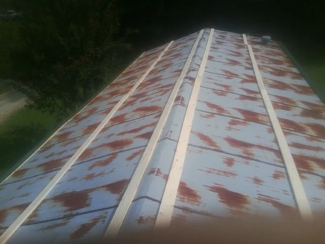 Rusted metal roof panels with new wood purlins before replacement — Storm Damage Roof Repair in Wellston by Roofing Brothers