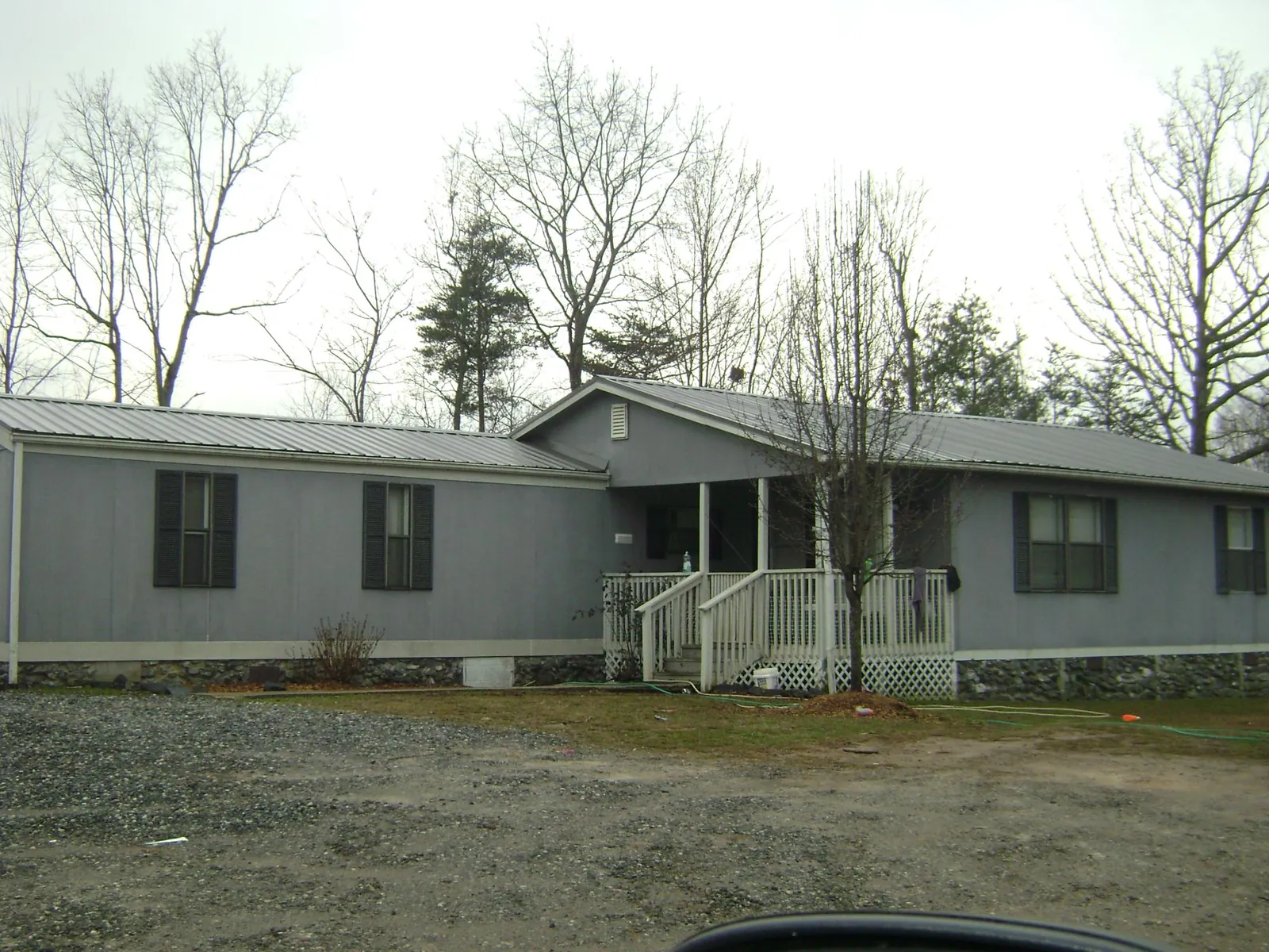 Metal roof over a manufactured home with a covered front porch in Wellston